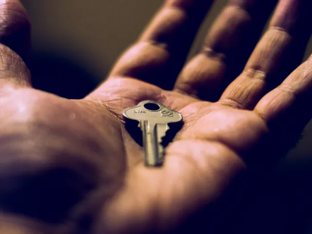 close up of a hand holding a key