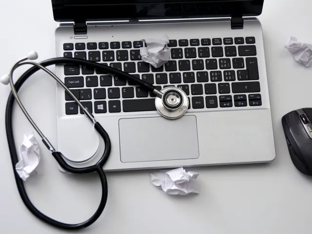 stethoscope sitting on top of a laptop