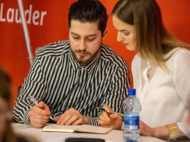 two people looking over a notebook in the innovation station