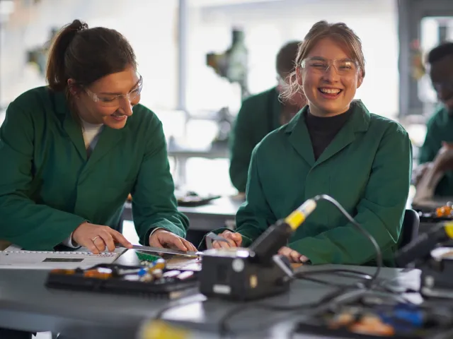 students in green work coats