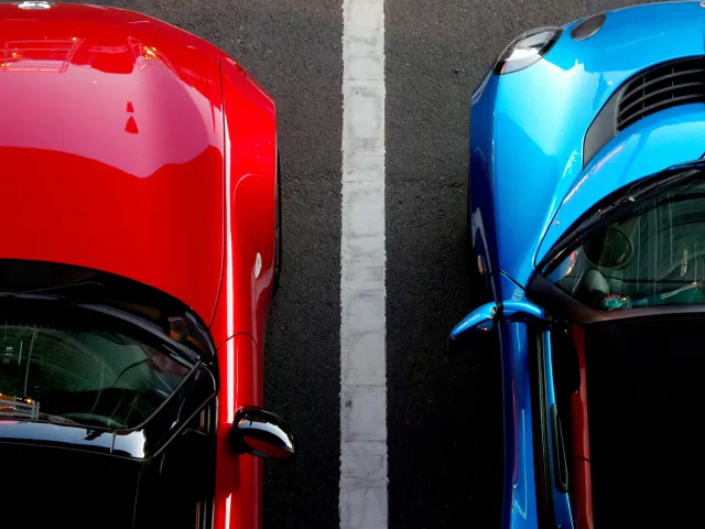 blue and red car parked next to one another