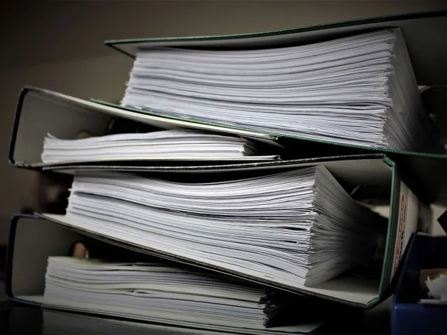 stack of binders full of papers
