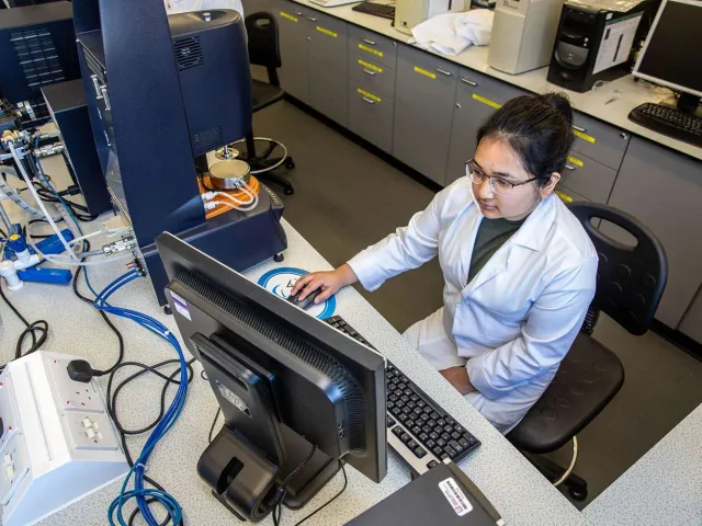 student in laboratory looking at laptop