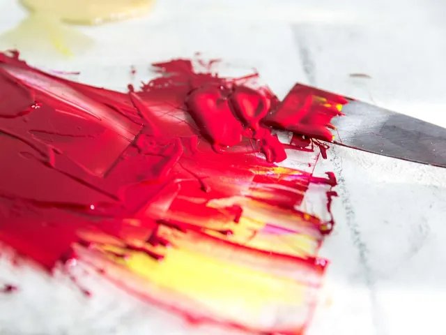 thick red paint on a canvas with a palette knife