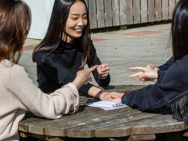 students laughing on a picnic bench