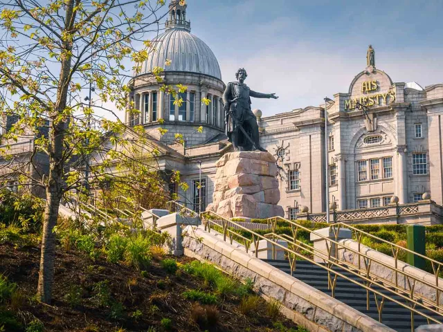 Statue at Aberdeen's Union Terrace Gardens with His Majesty's Theatre in the background