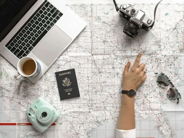 desk with laptop, passport and coffee