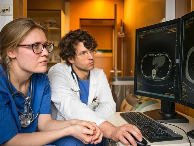 two health professionals looking at a body scan