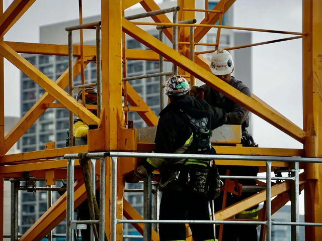 two workers on a yellow crane