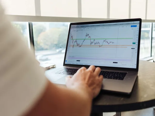 person using a laptop displaying a graph