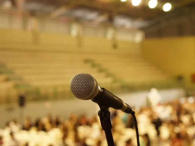 close up of a microphone in front of an audience