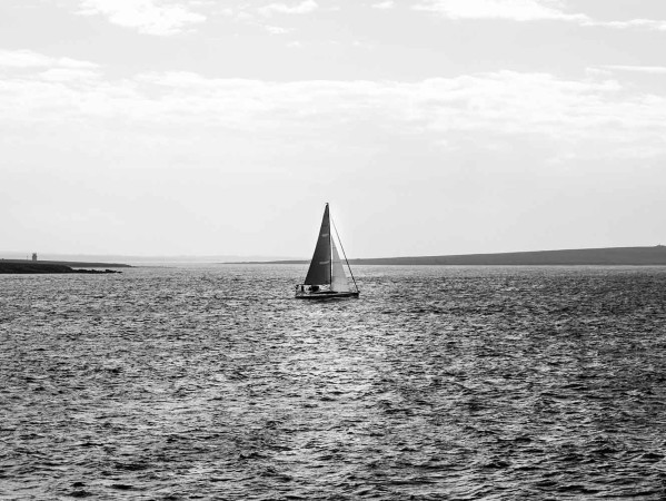 Black and white photograph of sail boat at sea in Orkney