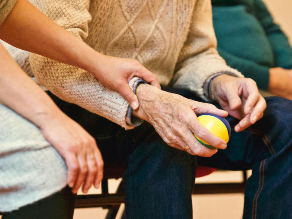older person holding a ball